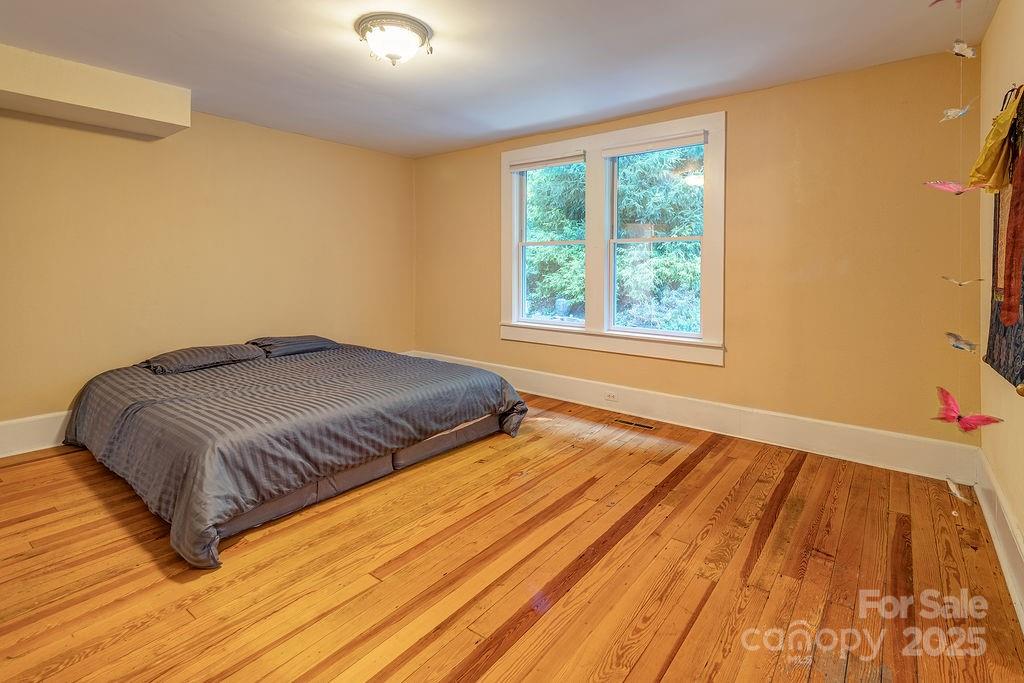 54 Spooks Branch Road Asheville, NC 28804 - Photo 17 of 41 a bedroom with a bed and wooden floor