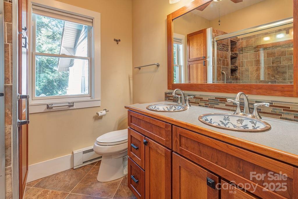 54 Spooks Branch Road Asheville, NC 28804 - Photo 19 of 41 a bathroom with a sink a toilet and a mirror