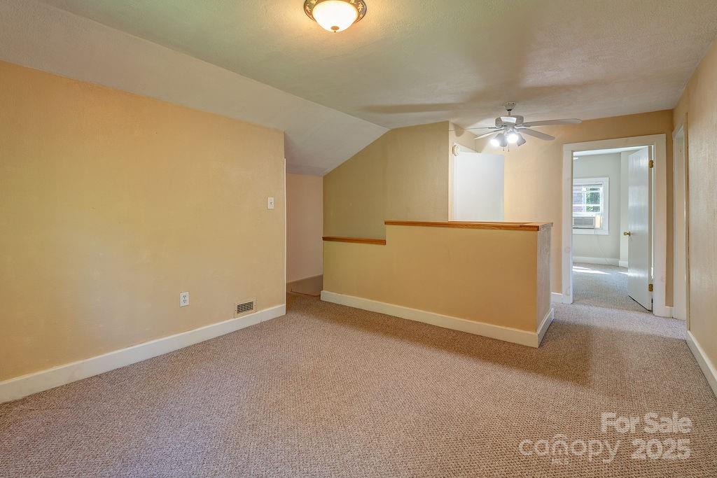 54 Spooks Branch Road Asheville, NC 28804 - Photo 23 of 41 an empty room with a chandelier fan and windows