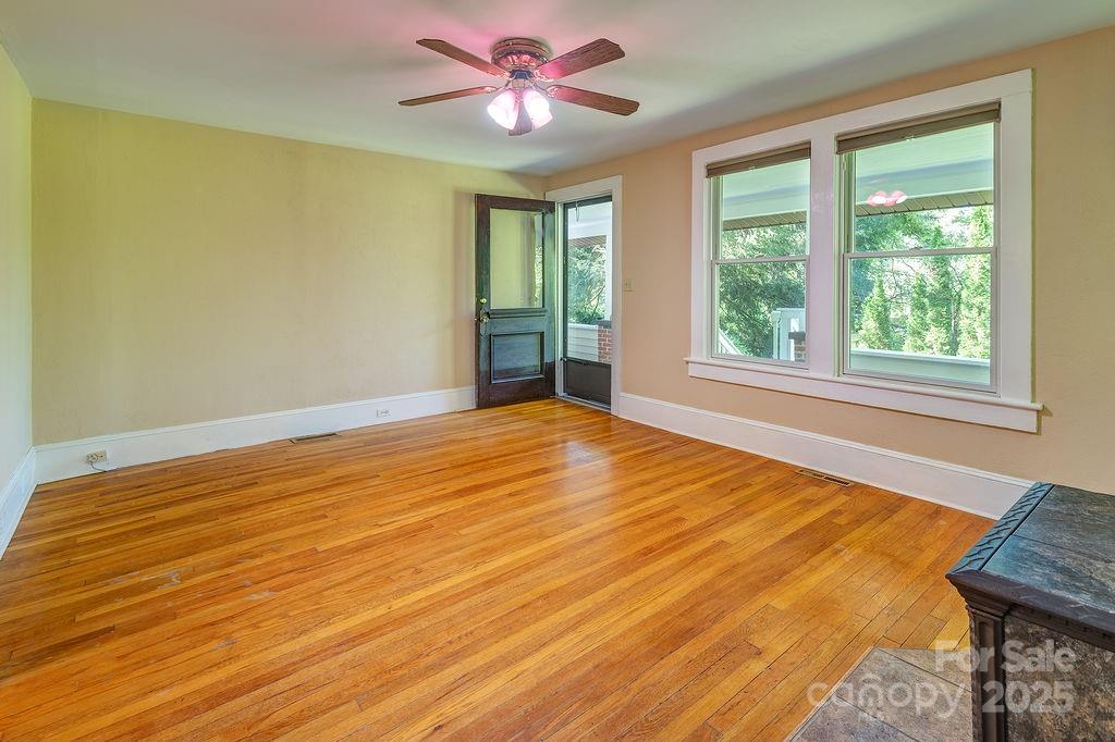 54 Spooks Branch Road Asheville, NC 28804 - Photo 4 of 41 a view of an empty room with window and wooden floor