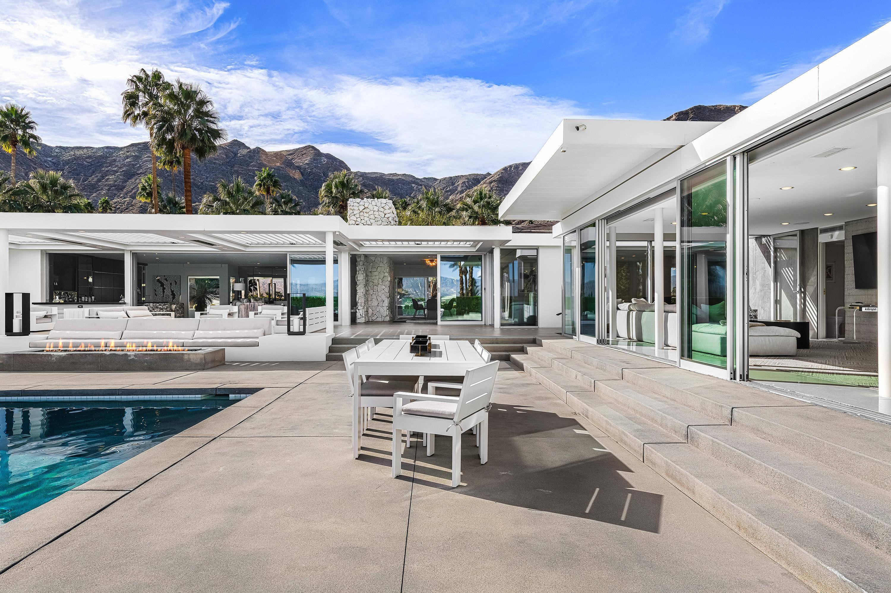 70260 Carson Road Rancho Mirage, CA 92270 - Photo 33 of 80 a view of a patio with table and chairs and floor to ceiling window