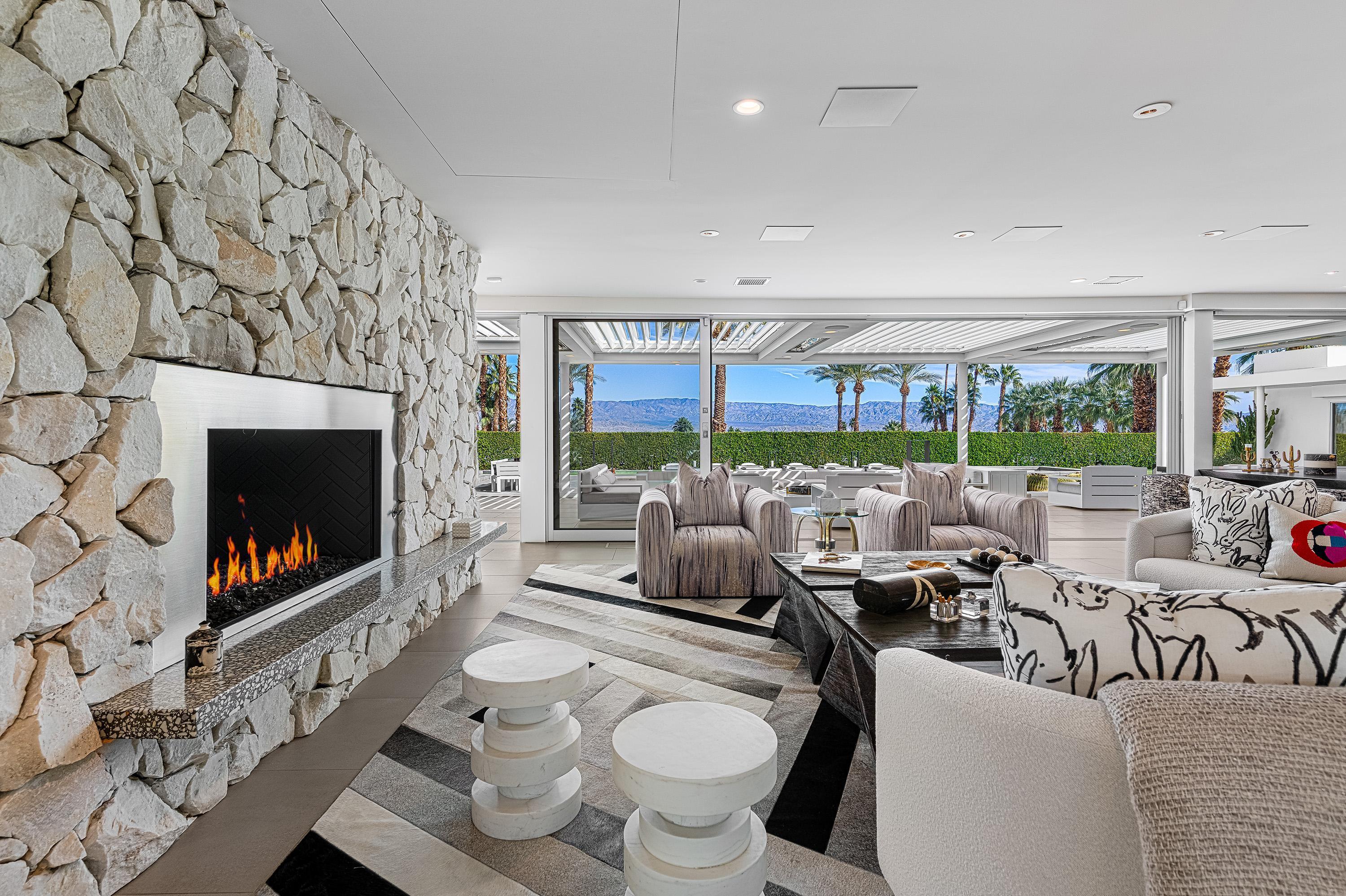 70260 Carson Road Rancho Mirage, CA 92270 - Photo 5 of 80 a living room with furniture a fireplace and a floor to ceiling window