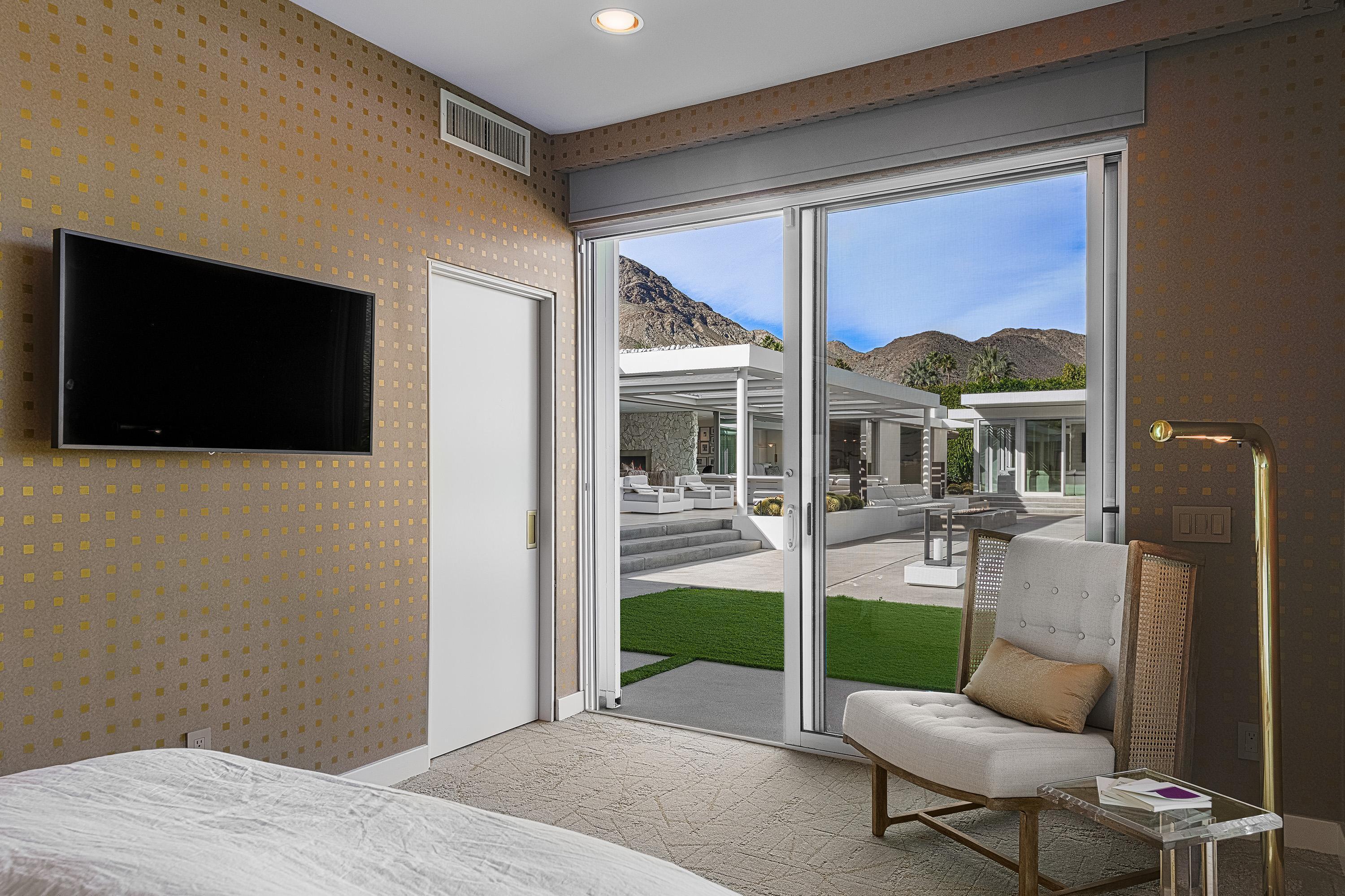 70260 Carson Road Rancho Mirage, CA 92270 - Photo 54 of 80 a living room with furniture a flat screen tv and a floor to ceiling window