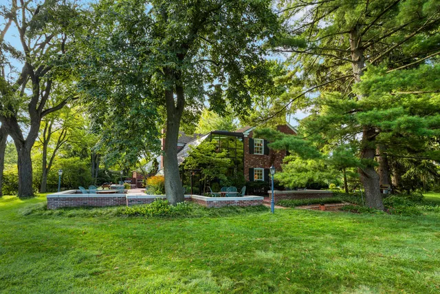 an aerial view of residential house with outdoor space and trees all around