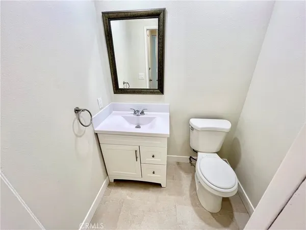 a bathroom with a toilet sink vanity and mirror