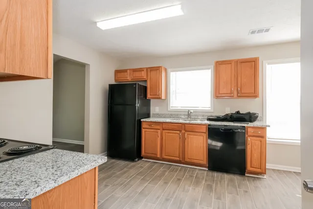 a kitchen with granite countertop stainless steel appliances and wooden cabinets
