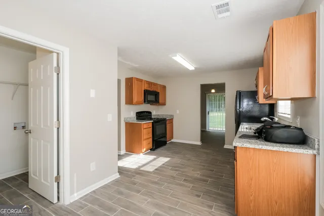 a kitchen with granite countertop a sink stove and refrigerator