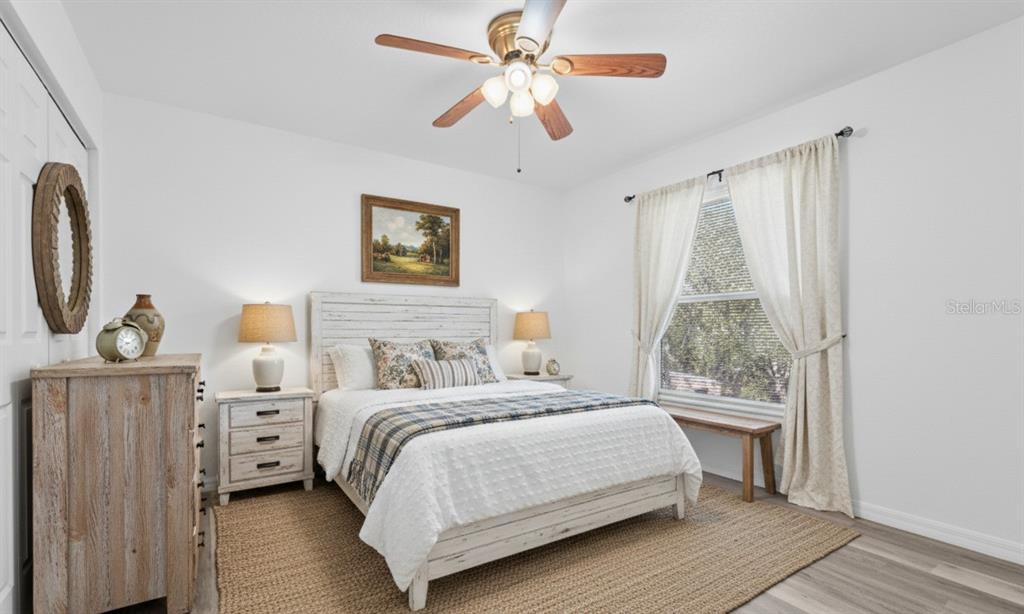 23655 Jennings Road Myakka City, FL 34251 - Photo 15 of 43 a bedroom with a large bed and a chandelier