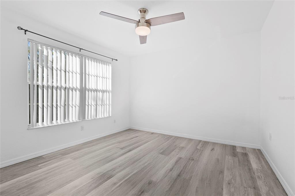 23655 Jennings Road Myakka City, FL 34251 - Photo 41 of 43 an empty room with wooden floor fan and windows