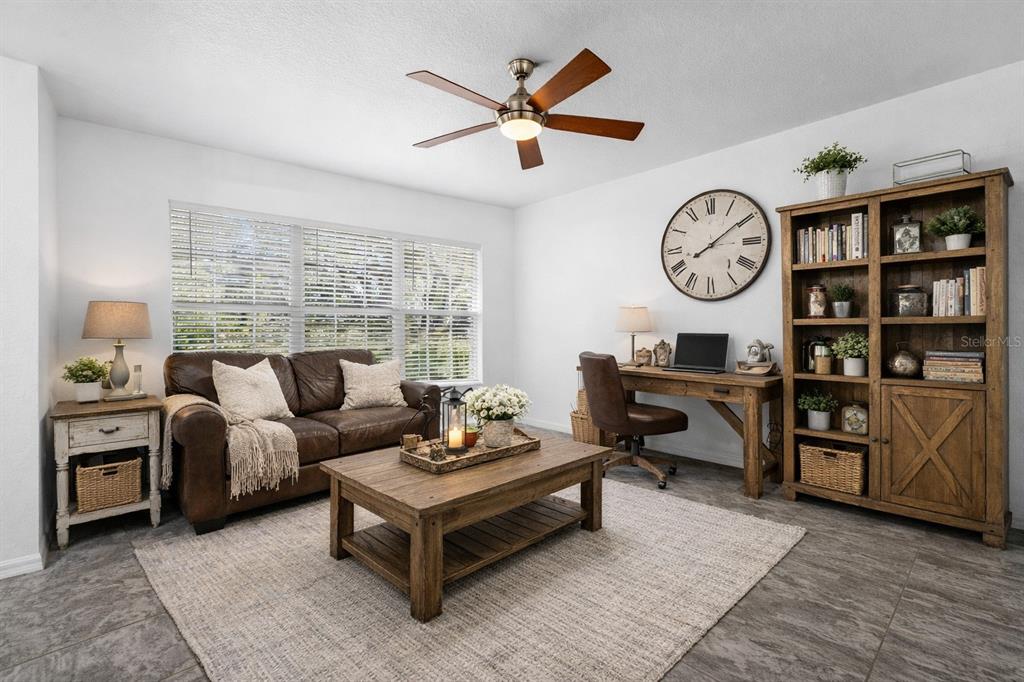 23655 Jennings Road Myakka City, FL 34251 - Photo 7 of 43 a living room with furniture a clock on wall and a window