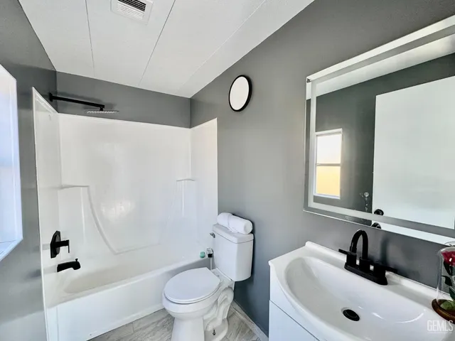 a bathroom with a sink a toilet and a mirror