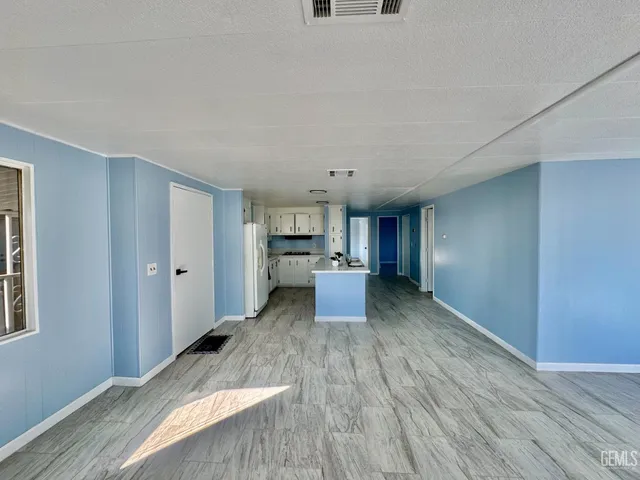 a view of a living room hardwood floor and a kitchen