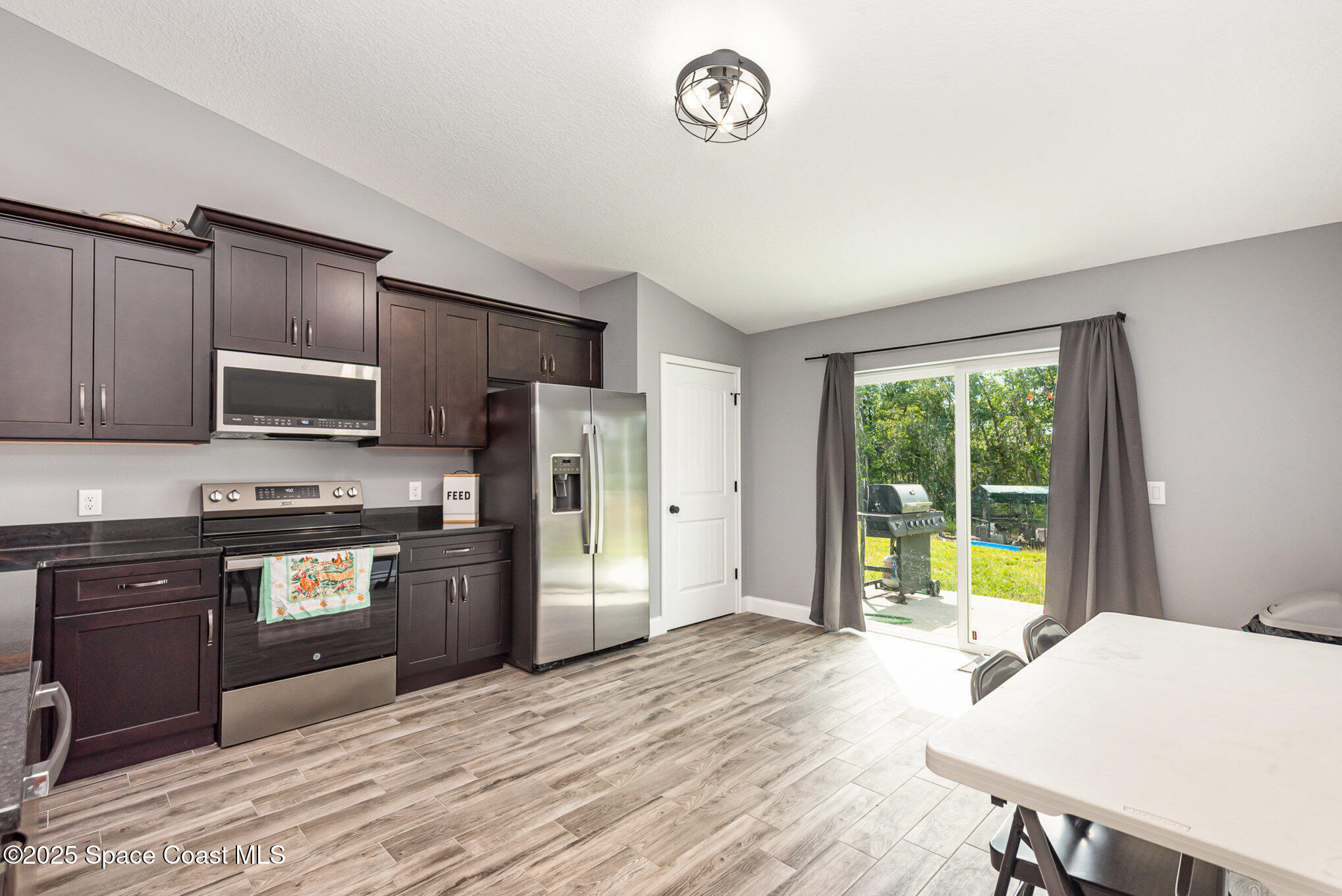 4110 Hog Valley Road Mims, FL 32754 - Photo 6 of 13 a kitchen with stainless steel appliances granite countertop a refrigerator stove top oven and sink