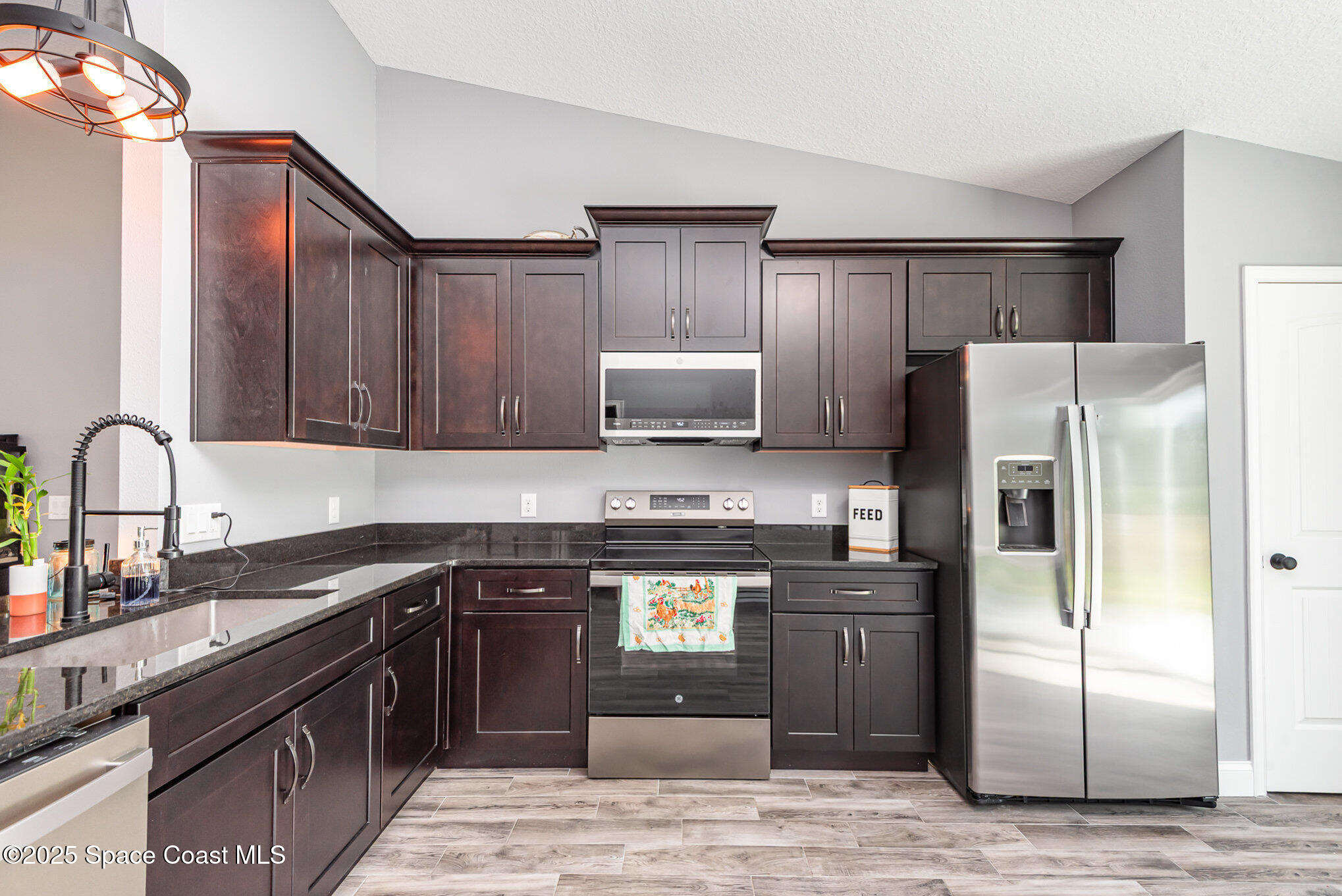 4110 Hog Valley Road Mims, FL 32754 - Photo 7 of 13 a kitchen with a refrigerator sink and cabinets