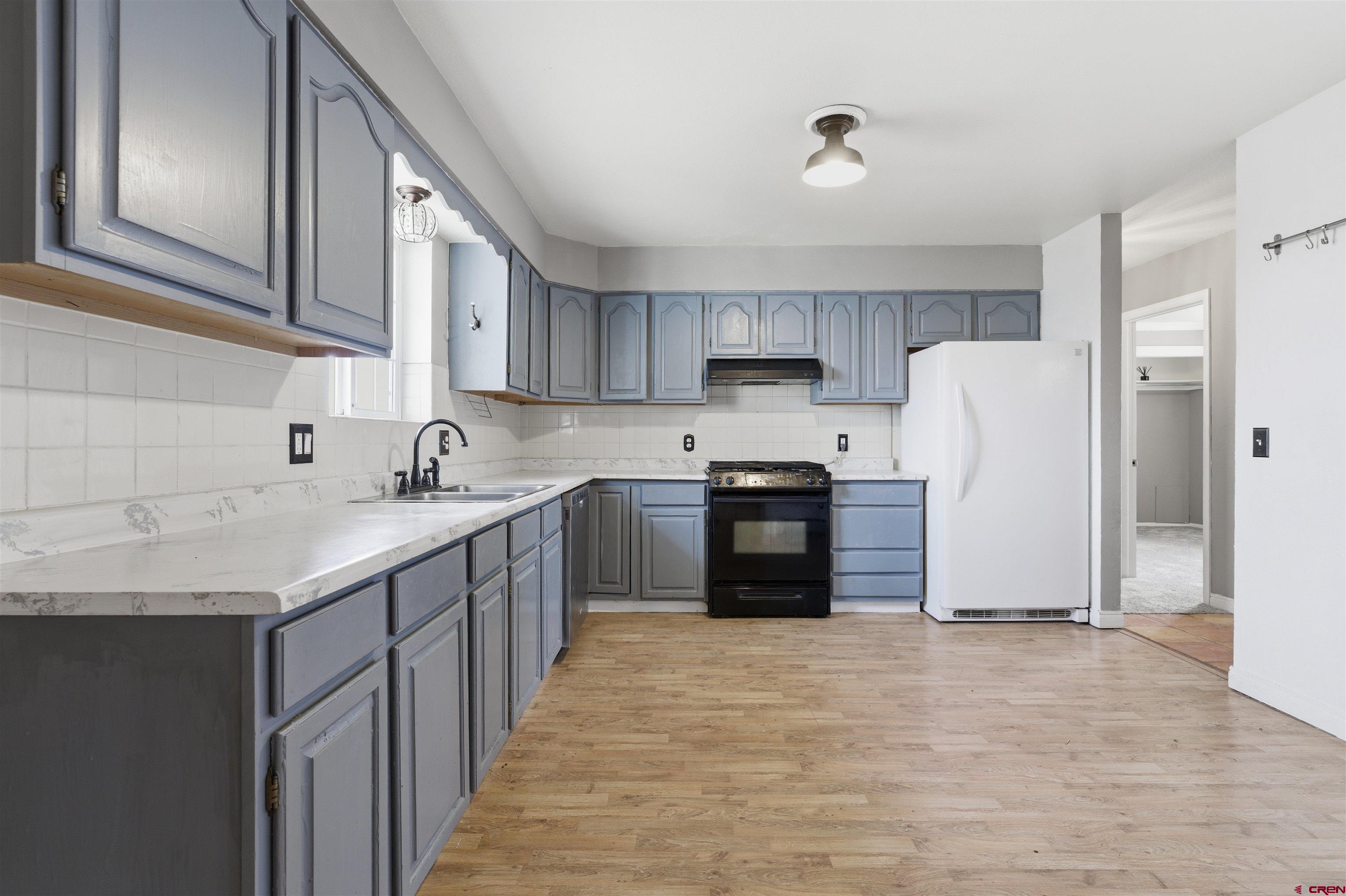 16216 2600th Road Cedaredge, CO 81413 - Photo 6 of 45 a kitchen with granite countertop a refrigerator a sink and a stove
