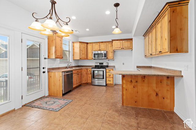 2092 Cres Drive South Mapleton, UT 84664 - Photo 7 of 26 Kitchen featuring warm wood cabinetry, stainless steel appliances, durable tiled flooring, and a breakfast bar