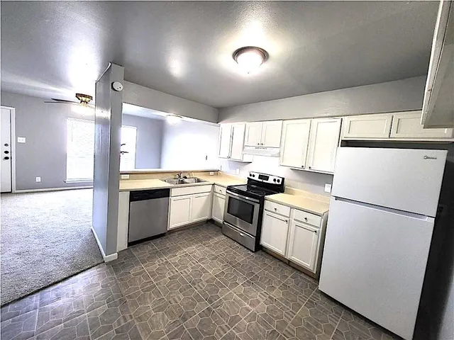 a kitchen with a sink a refrigerator and a stove