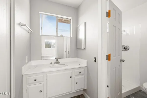 a bathroom with a sink vanity granite and a mirror