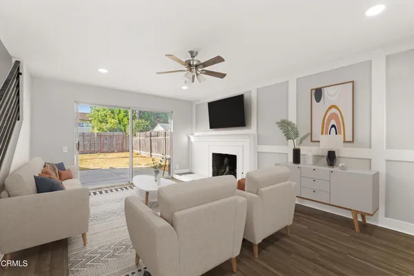 a living room with furniture a fireplace and a flat screen tv