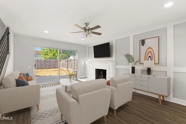 a living room with furniture a fireplace and a flat screen tv