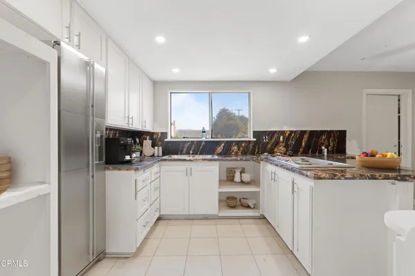 a kitchen with stainless steel appliances kitchen island granite countertop a refrigerator and a stove top oven
