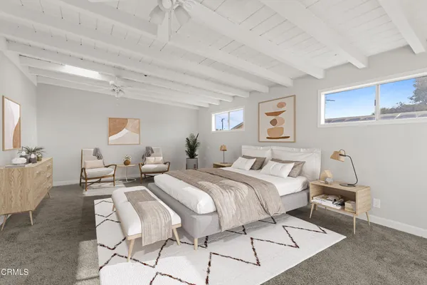 a spacious bedroom with a bed a table and chair