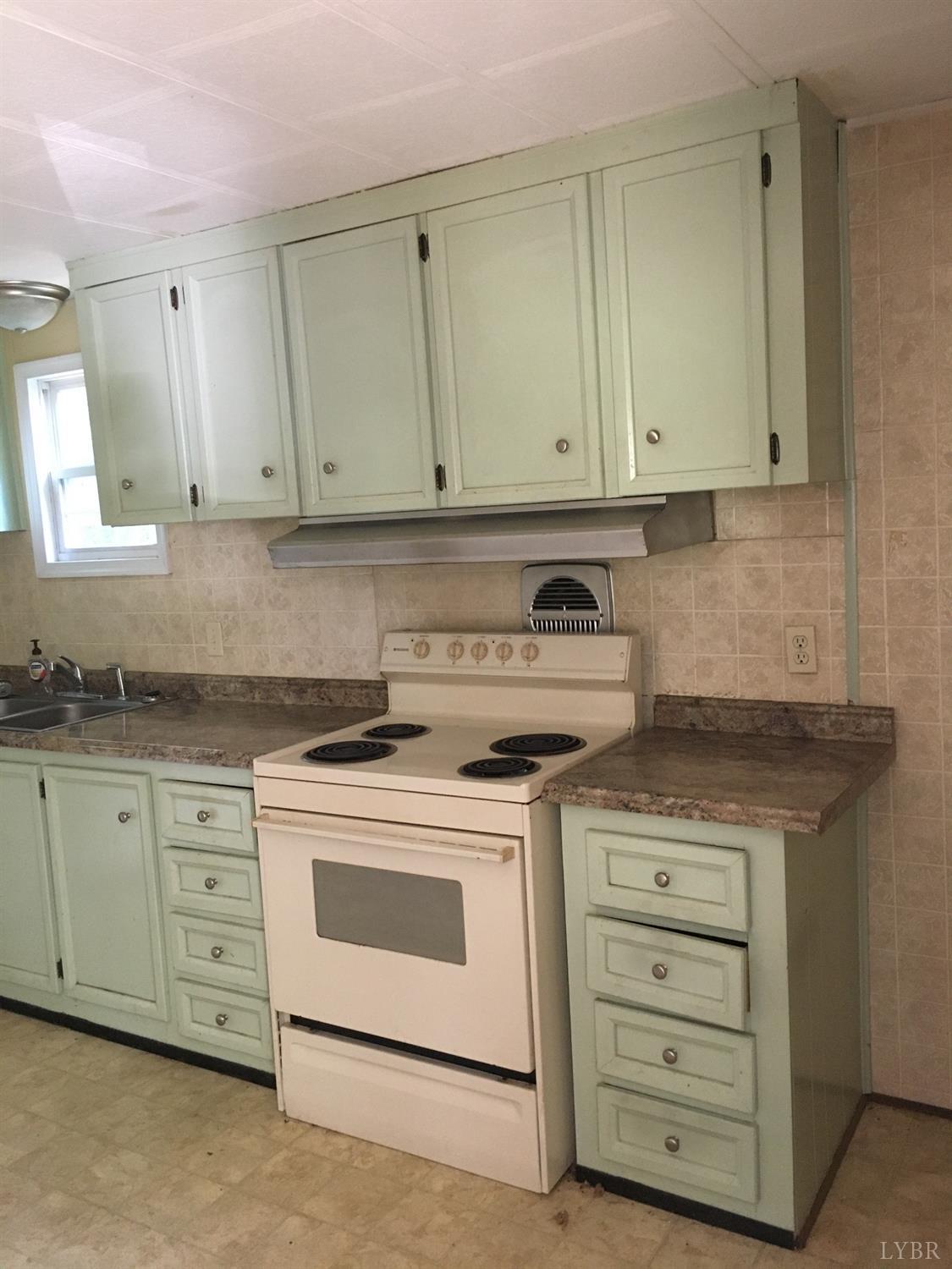 1066 Stevens Cove Road Lovingston, VA 22949 - Photo 8 of 15 a kitchen with granite countertop white cabinets and a stove