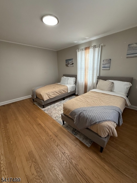 335 Hobson Street Newark, NJ 07112 - Photo 16 of 29 a bedroom with a bed and wooden floor