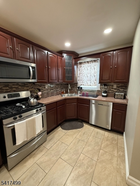 335 Hobson Street Newark, NJ 07112 - Photo 7 of 29 a kitchen with stainless steel appliances granite countertop a stove top oven a sink dishwasher a refrigerator and a cabinets