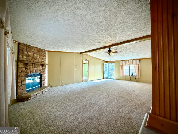 a view of an empty room with a fireplace and a window