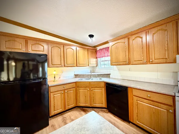 a large kitchen with stainless steel appliances granite countertop a stove a sink dishwasher and a refrigerator