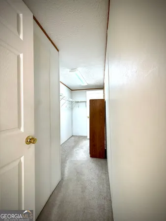 a view of a big room with windows and chandelier fan
