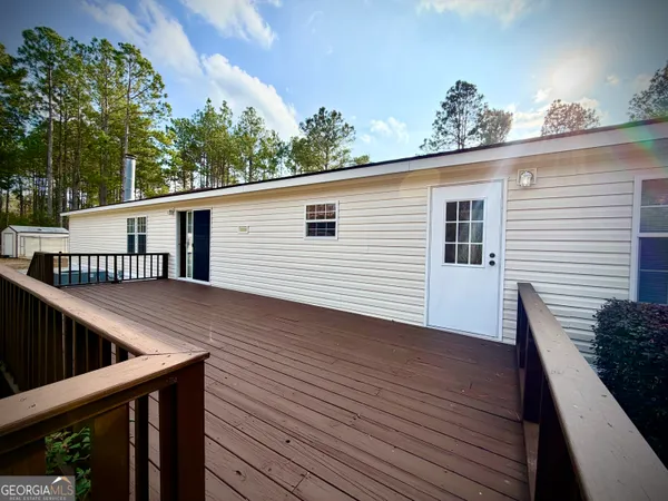 a view of a deck with wooden floor and fence with a potted plant