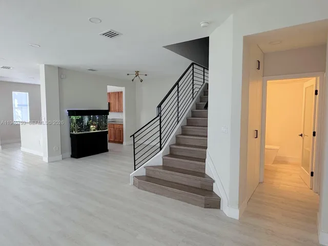 an aerial view of a house with a yard and a large tree