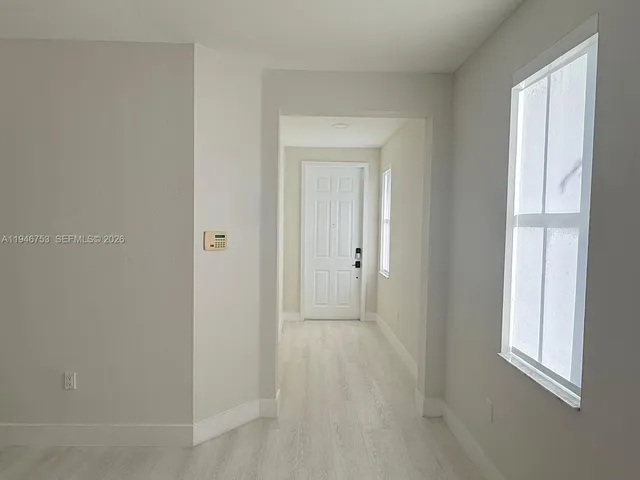 a view of a hallway with wooden floor and staircase