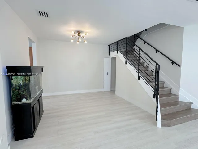 an empty room with windows and fireplace