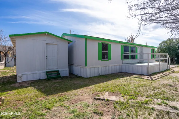 a view of a house with a yard and wooden fence