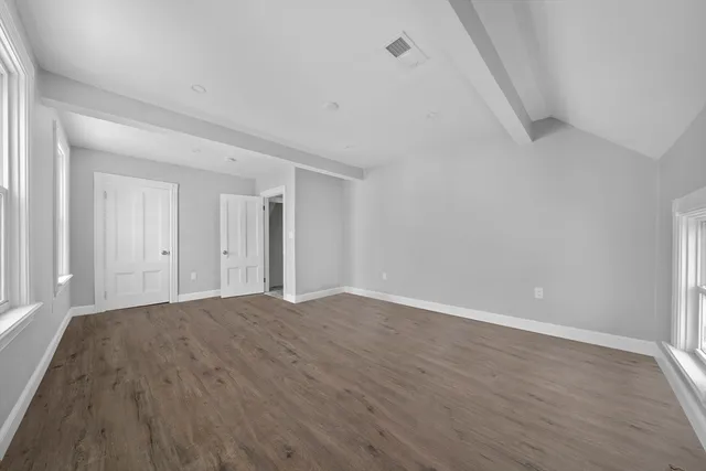 a view of an empty room and wooden floor