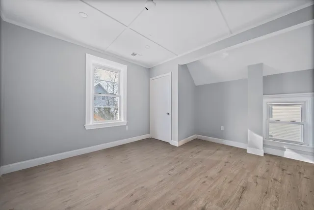 an empty room with windows and closet