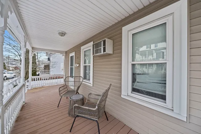 a view of a porch with furniture and wooden floor
