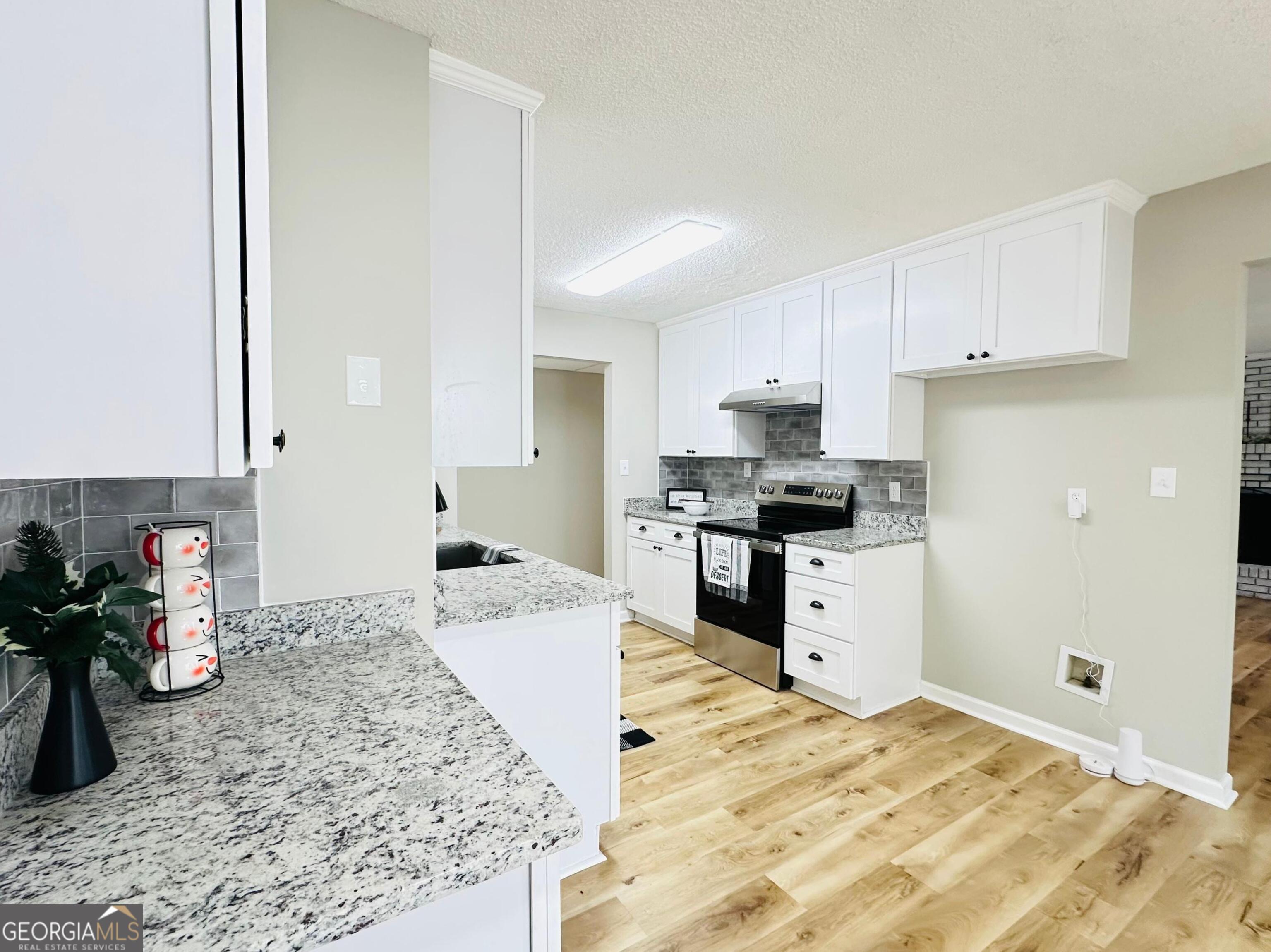 1610 Lance Drive Dublin, GA 31021 - Photo 25 of 38 a kitchen with granite countertop a sink stove and cabinets