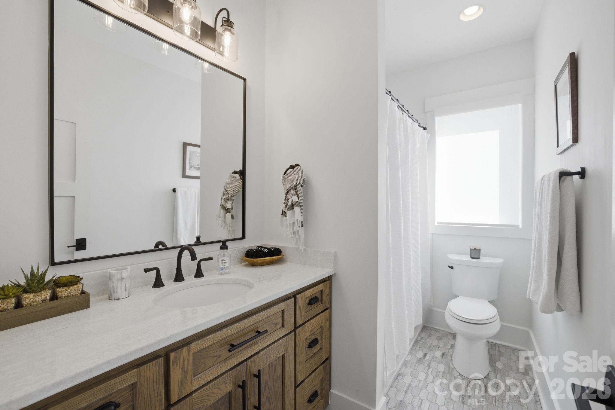 7748 Harbor Lane Denver, NC 28037 - Photo 33 of 42 a bathroom with a granite countertop sink a toilet and a mirror