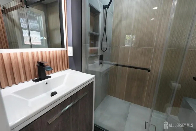 a bathroom with a sink a mirror and shower