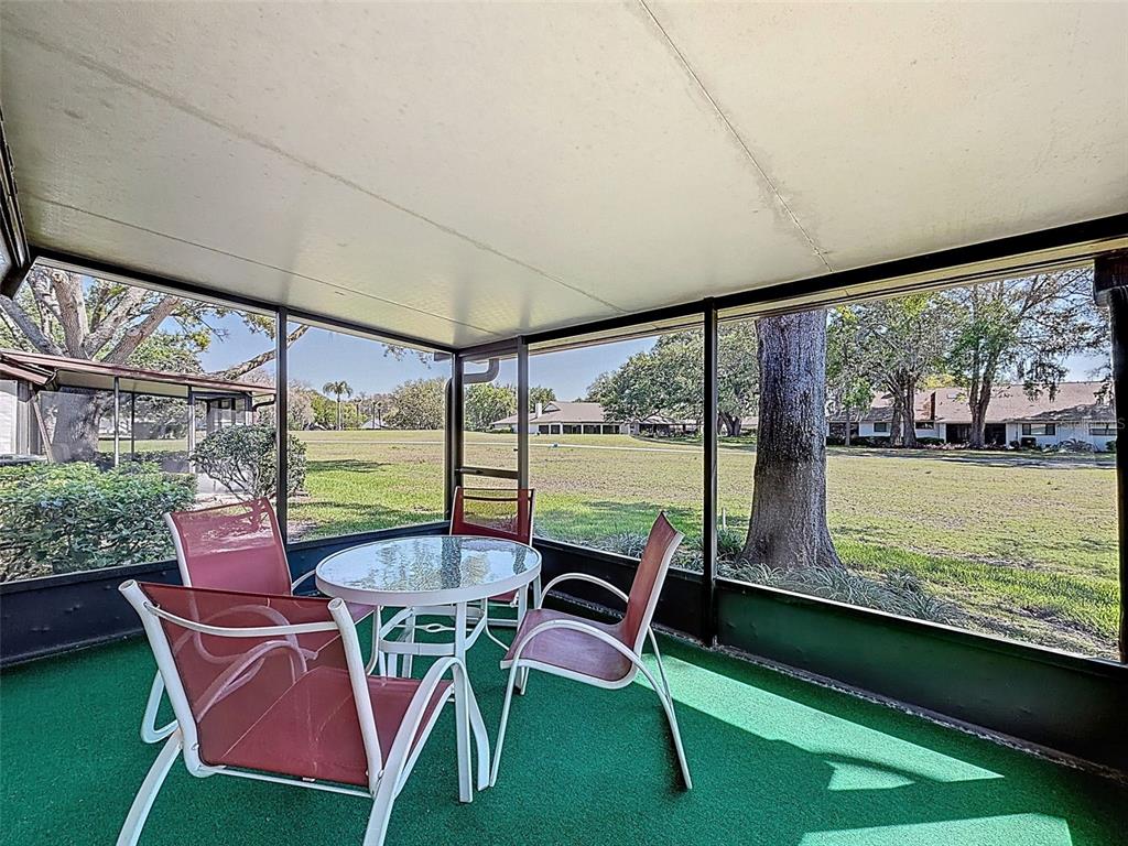 3504 Niblick Court, Unit 4 New Port Richey, FL 34655 - Photo 26 of 58 a view of a porch with furniture and a yard