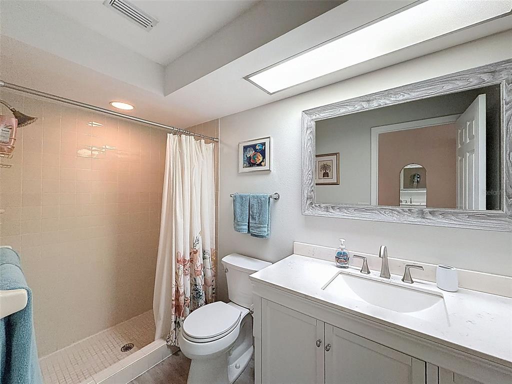 3504 Niblick Court, Unit 4 New Port Richey, FL 34655 - Photo 32 of 58 a bathroom with a granite countertop sink a toilet and a mirror