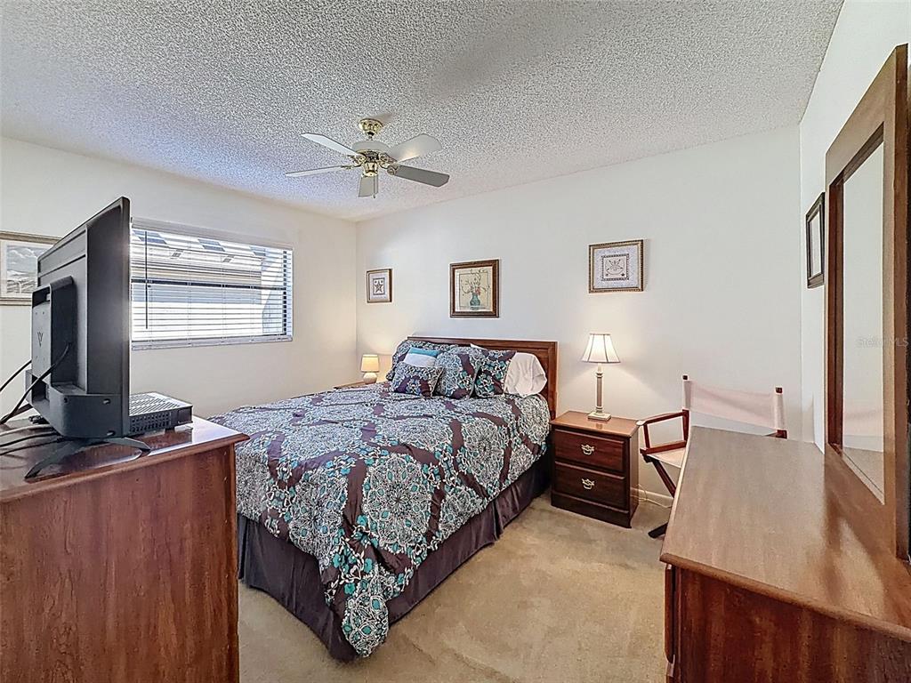 3504 Niblick Court, Unit 4 New Port Richey, FL 34655 - Photo 37 of 58 a bedroom with a bed and a flat tv screen on dresser