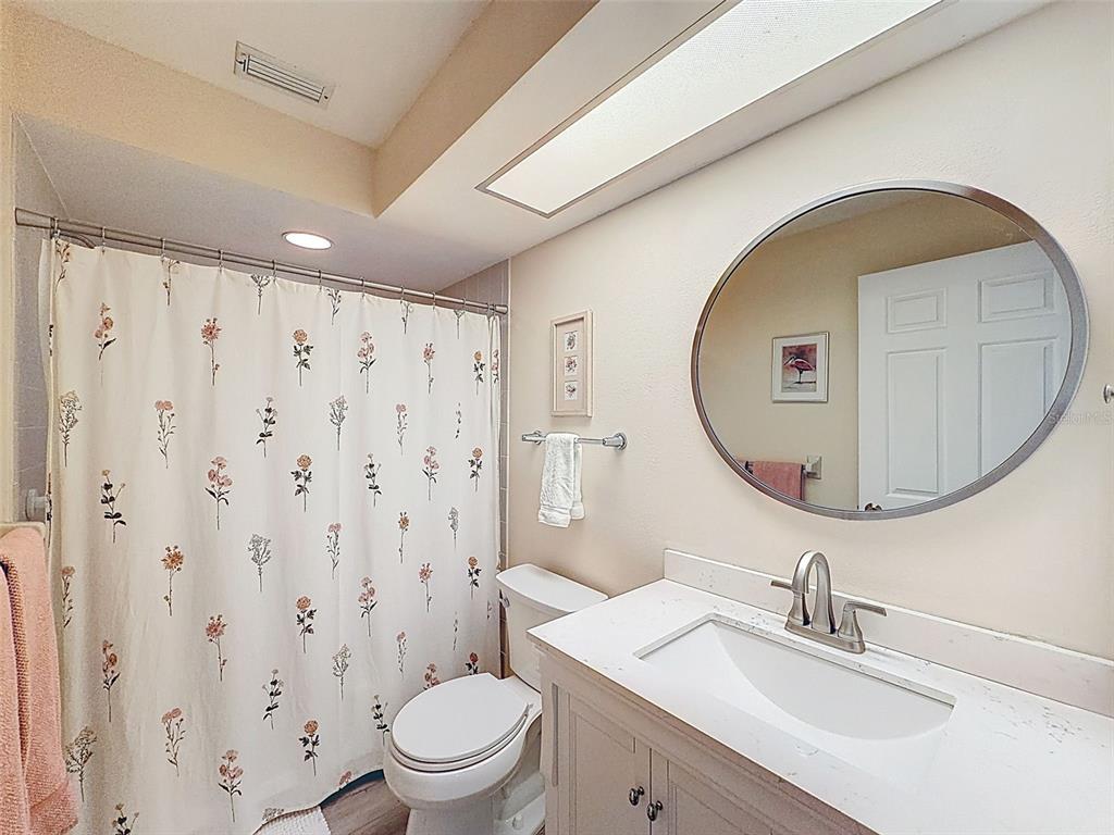 3504 Niblick Court, Unit 4 New Port Richey, FL 34655 - Photo 39 of 58 a bathroom with a sink a mirror a toilet and a mirror