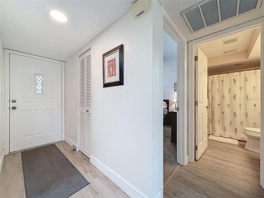 3504 Niblick Court, Unit 4 New Port Richey, FL 34655 - Photo 4 of 58 a view of a hallway with wooden floor and a bathroom