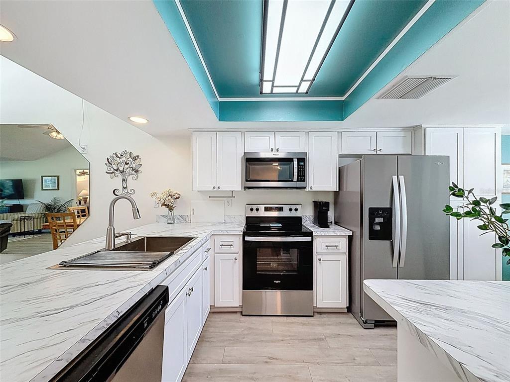 3504 Niblick Court, Unit 4 New Port Richey, FL 34655 - Photo 6 of 58 a kitchen with stainless steel appliances granite countertop a sink a stove a refrigerator cabinets and chairs
