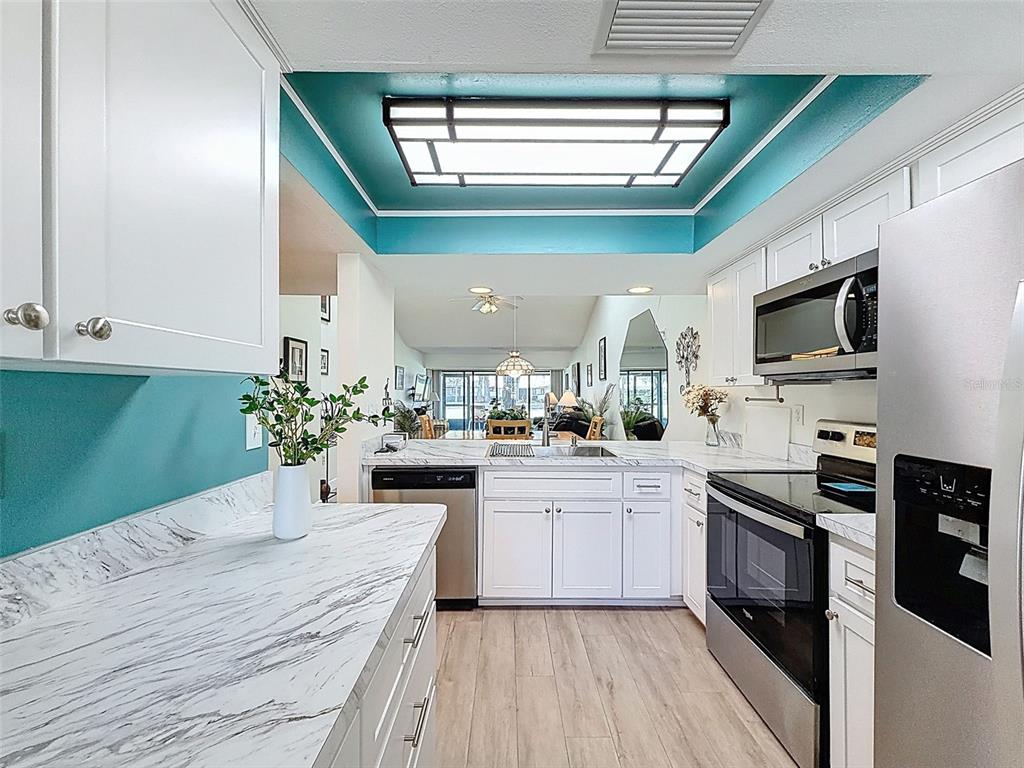 3504 Niblick Court, Unit 4 New Port Richey, FL 34655 - Photo 9 of 58 a kitchen with kitchen island a sink stainless steel appliances and cabinets